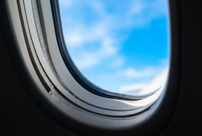 Kuwait Airways et la liste noire européenne en 2026 Vue depuis le hublot d'un avion avec un ciel bleu lumineux
